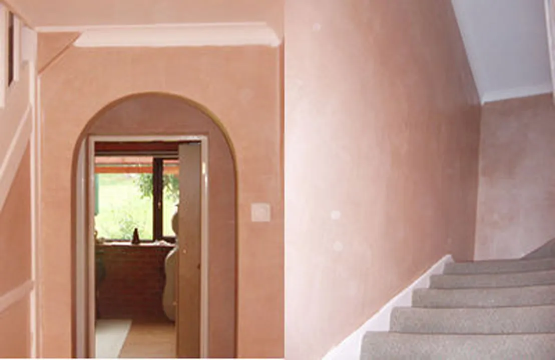 Freshly skimmed hallway and staircase with an arched doorway, plastered by A.I. Myles Plastering Service in Dorking