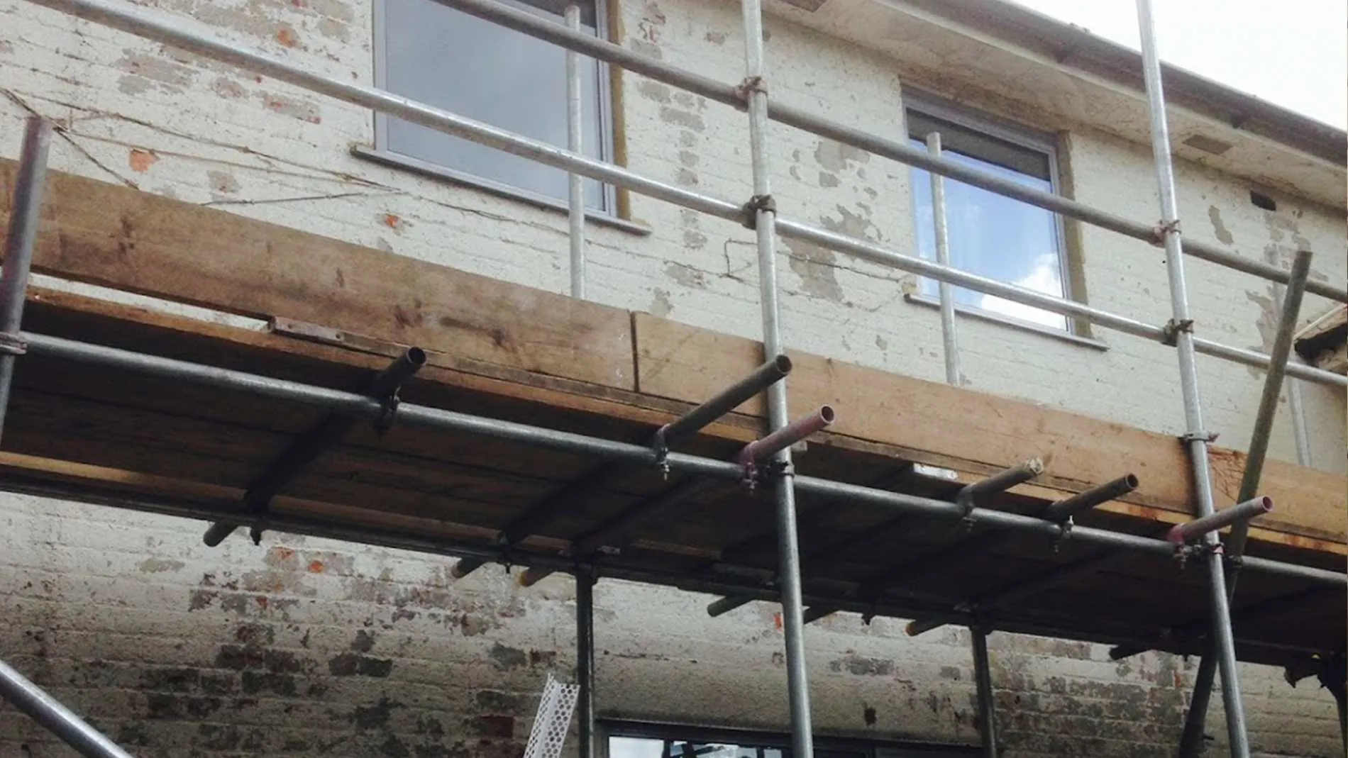 Old brick elevation stripped back and scaffolded ready for render, Surrey